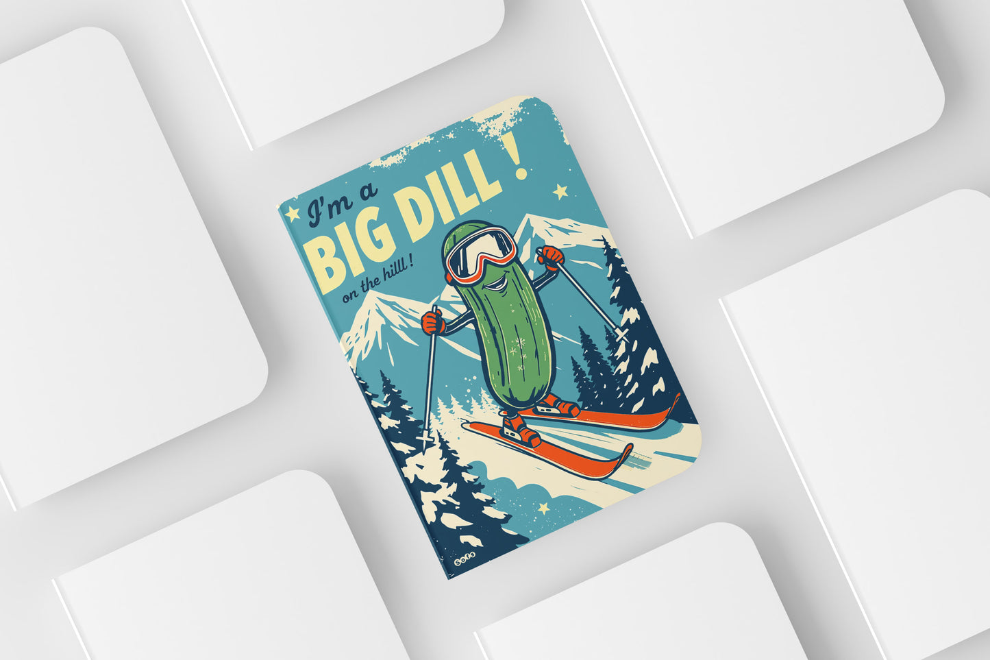 Skiing pickle with goggles and skis on a blue background with text 'I'm a Big Dill' on a white surface.